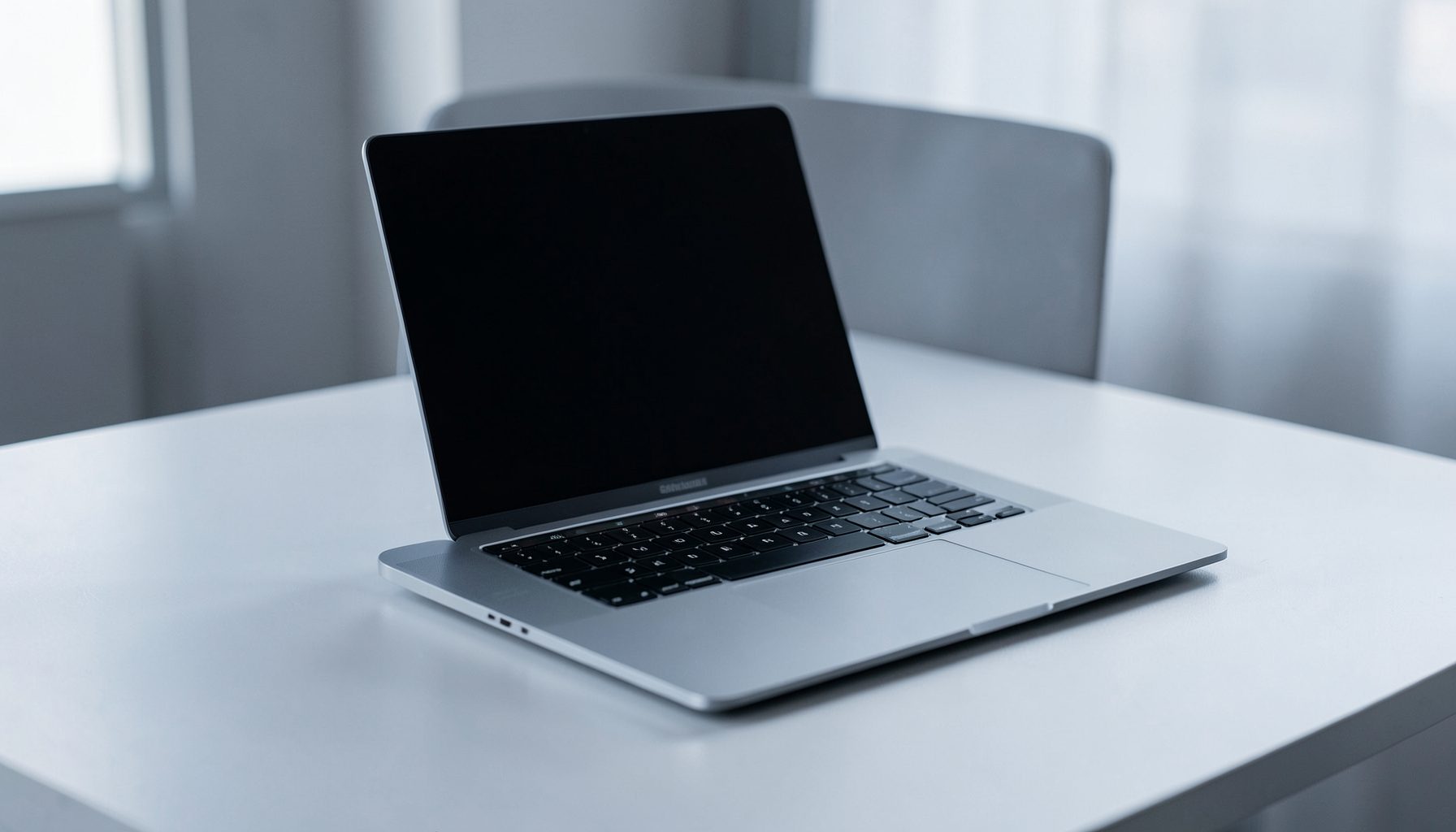 Sleek laptop on a clean desk with soft natural lighting, modern and minimal atmosphere in cool gray tones